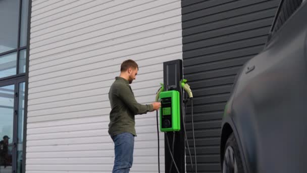 Man Uses Mobile Application Charging Electric Car — Stock Video