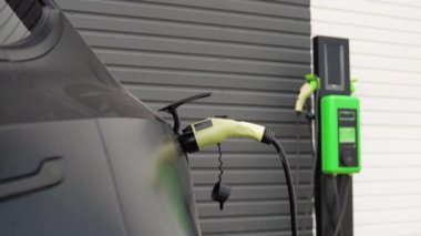 Otoparkta şarj aleti olan elektrikli bir arabayı şarj etmek..