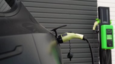 Otoparkta şarj aleti olan elektrikli bir arabayı şarj etmek..