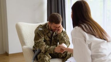 Psikolog üzgün erkek asker, Ptsd ile terapi oturumu sırasında notlar yapma