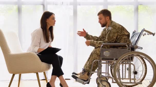 坐在轮椅上穿着迷彩服 身无分文 身无分文的男人去看心理医生 — 图库视频影像