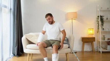 Koltuk değneği olan bir adam kırık bir bacaktan dolayı acı çeker..