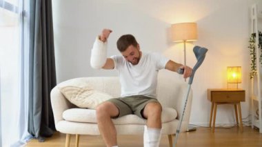 Kırık eli, ayağı ve koltuk değneği olan bir adam arabayla gezintiyi betimliyor..