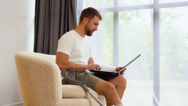 Freelancer Homem Insalubre Com Perna Ferida Bandagem Sentar Sofá Casa — Vídeo de Stock