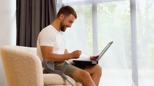 Bonito Homem Com Perna Quebrada Usando Laptop Sofá — Vídeo de Stock