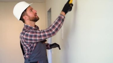 İşçi yeni dairede duvar boyuyor..