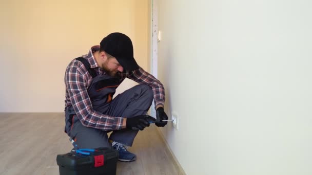 Electricien Professionnel Salopette Capuchon Noir Installant Une Prise Sur Mur — Video