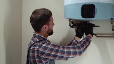 Üniformalı profesyonel tesisatçı yeni evine kazan kuruyor..
