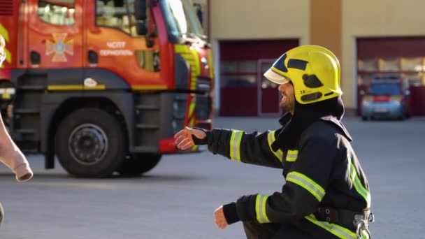 Brave Firefighter Uniform Hugs Little Boy Fire Engine — Stock Video