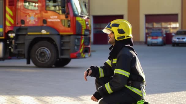 Пожежник Уніформі Обіймає Маленького Хлопчика Біля Пожежного Двигуна Станції — стокове відео