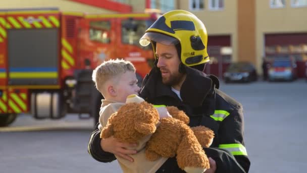 Portrait Brave Fireman Holds Saved Boy His Arms Standing Fire — Stock Video