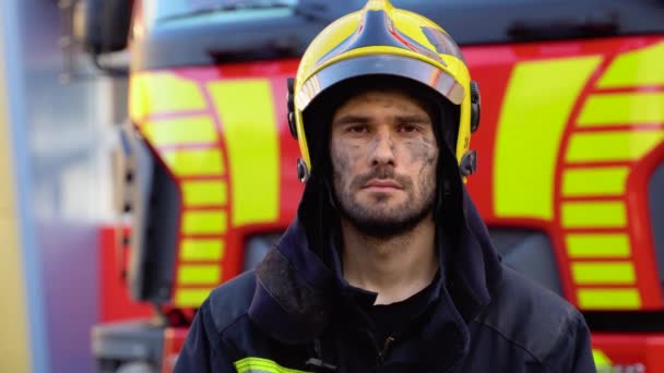 火災エンジンの近くの保護ヘルメットの疲れた消防士 — ストック動画