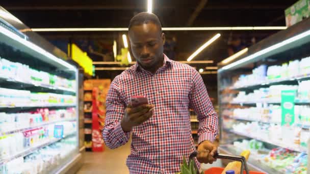 Черный Человек Делает Заметки Списке Покупок Своем Смартфоне — стоковое видео