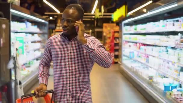 Hombre Negro Guapo Caminando Mirando Alrededor Supermercado Habla Por Teléfono — Vídeo de stock