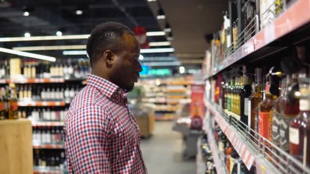 Черный Мужчина Супермаркете Выбирает Роскошный Алкоголь Винном Отделе — стоковое видео