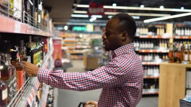 Ein Schwarzer Mann Einem Supermarkt Wählt Luxusalkohol Der Weinabteilung — Stockvideo