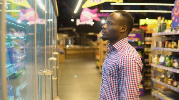 スーパーで買い物をしているアフリカ系アメリカ人男性 冷たいお酒を買って — ストック動画