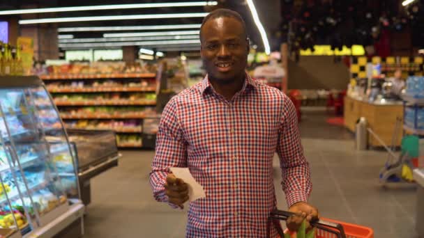 Африканский Американец Смотрит Цены Товары Наличной Квитанции После Покупки Торговом — стоковое видео