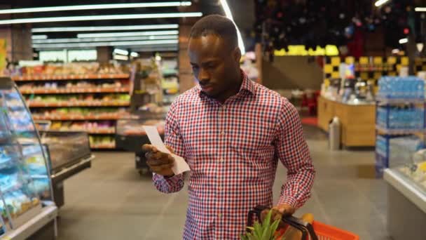 Nero Scioccato Guarda Una Ricevuta Carta Supermercato Dopo Shopping Gli — Video Stock