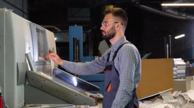 Dijital matbaa ofisindeki dokunmatik ekran monitör istasyonundaki girdi ve çıktı durumunu kontrol eden teknisyen