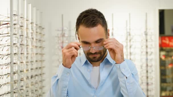 Portret Przystojnego Mężczyzny Wybierającego Nowe Okulary Sklepie Optycznym — Wideo stockowe