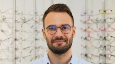 Optik mağazasında yeni gözlüklü bir adamın portresi.