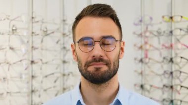 Optik mağazasında hayal kırıklığına uğramış bir adamın portresi.