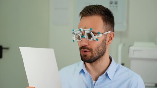 眼科オフィスで診察中に眼鏡で視力をチェックする男性 — ストック動画