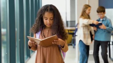 Eğitim Konsepti. Sınıfta kitap okuyan tatlı Afrikalı Amerikalı kızın portresi.