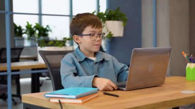 Evde dizüstü bilgisayar kullanarak video dersi alan bir çocuk..