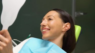 Ayna dişlerde kontrol adı ne? Dişçi ofisinde genç kadın. Yeni Diş implantları.