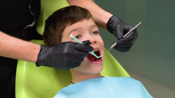 Stomatologia Dziecięca Pierwsze Badanie Dentysty Słodki Chłopiec Otwartymi Ustami Patrzy — Wideo stockowe
