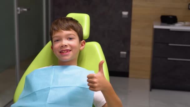 Portret Szczęśliwego Chłopca Patrzącego Kamerę Uśmiechniętego Podczas Siedzenia Gabinecie Stomatologicznym — Wideo stockowe