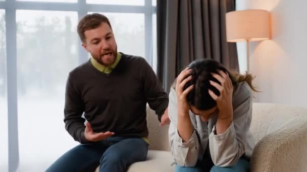 リビングルームに座ってソファーに座り 意見の相違を主張し 女性に怒鳴り 夫から心理的虐待を受けた女性 — ストック動画