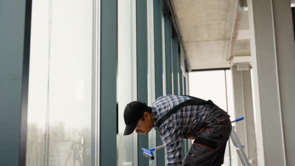 男性の専門的な清掃サービス労働者は 特別な設備を備えた店の窓や店の窓を掃除します — ストック動画