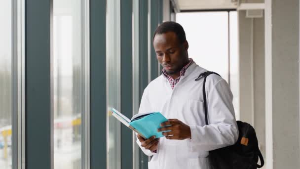 Afrykański Amerykański Student Medycyny Czyta Książkę Uniwersytecie Stażysta Przygotowuje Się — Wideo stockowe