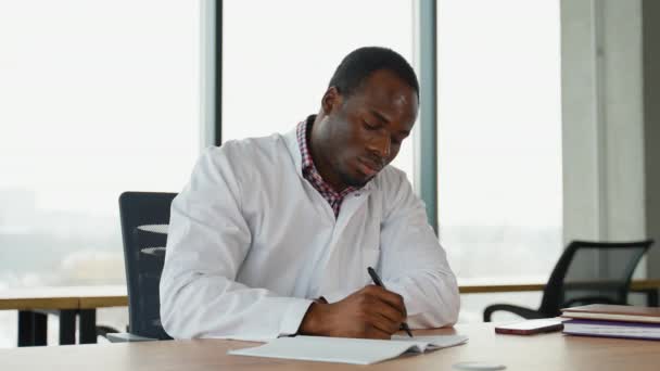 Estressado Frustrado Médico Preto Uniforme Branco Com Dor Cabeça Sentado — Vídeo de Stock