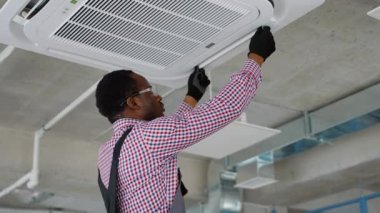 Modern klimayı iç mekanlarda koruyan profesyonel teknisyen.