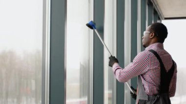 Profesyonel pencere temizleyicisi pencereyi içeride yıkıyor..