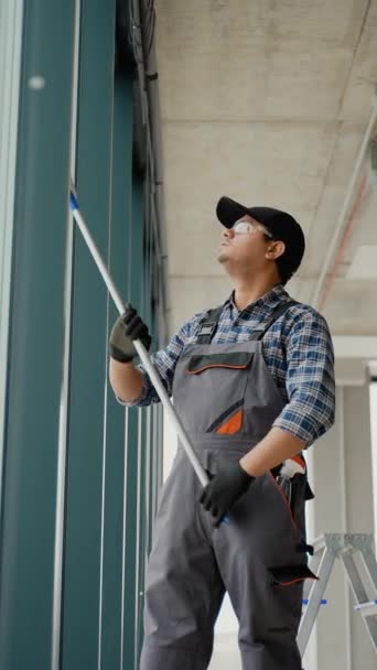 Asiatische Männliche Professionelle Reinigungskraft Putzt Die Fenster Und Schaufenster Eines — Stockvideo