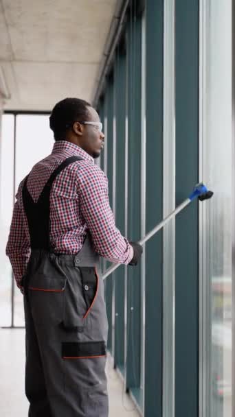 Schwarzer Mann Professionelle Reinigungskraft Overalls Reinigt Die Pvc Fenster Büro — Stockvideo