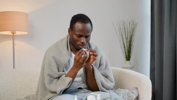 African Man Runny Nose Sits Couch Home Plaid Sneezing Napkin — Stock Video
