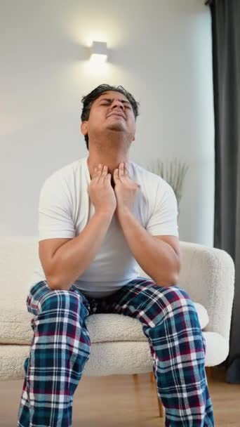 ソファーで自宅で頭痛を抱えているインドのアジアの男 — ストック動画