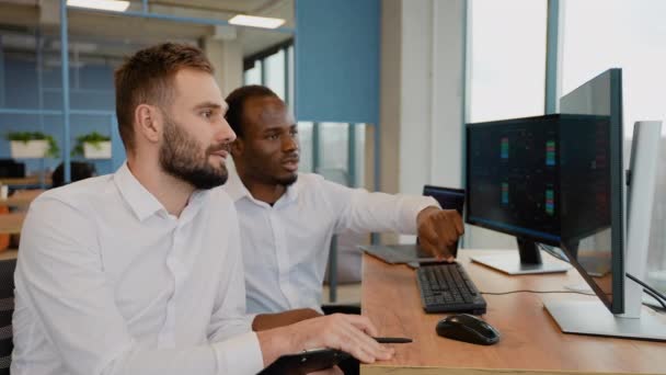 两个密码交易商坐在电脑前 对烛台图进行专业分析 制定策略 拿着笔和笔记本 看着监视器 — 图库视频影像