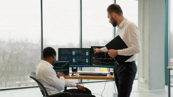 两名在职男性交易员一起在屏幕上监控股票数据蜡烛图 — 图库视频影像