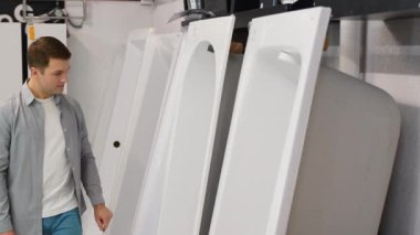 Bir adam banyo mobilyalarında seramik veya akrilik banyo yapmayı tercih ediyor..