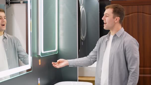 Een Man Kiest Spiegel Voor Badkamer Winkel — Stockvideo