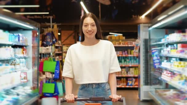 Γυναίκα Κάνει Ψώνια Στο Σούπερ Μάρκετ Σπρώχνει Ένα Καλάθι Αγορών — Αρχείο Βίντεο