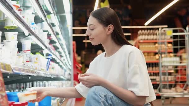スーパーマーケットでアイスクリームを買う美しい女性の側面 — ストック動画