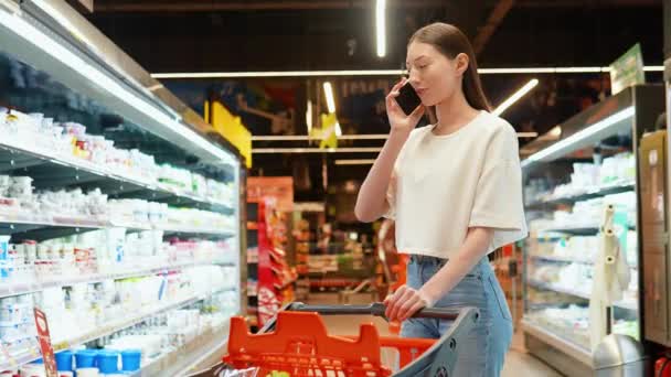 Schöne Frau Supermarkt Kauft Ein Wählt Produkte Und Telefoniert Berät — Stockvideo